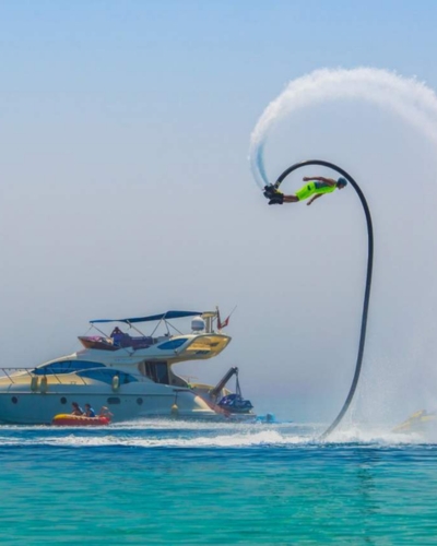 Flyboarder soaring above the water near a yacht in Dubai