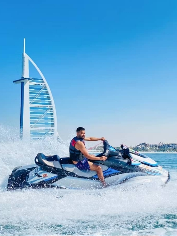 Jet ski splashing through water with Burj Al Arab in background