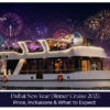 Guests enjoying a festive dinner aboard a Dubai cruise with city lights and waterfront views.