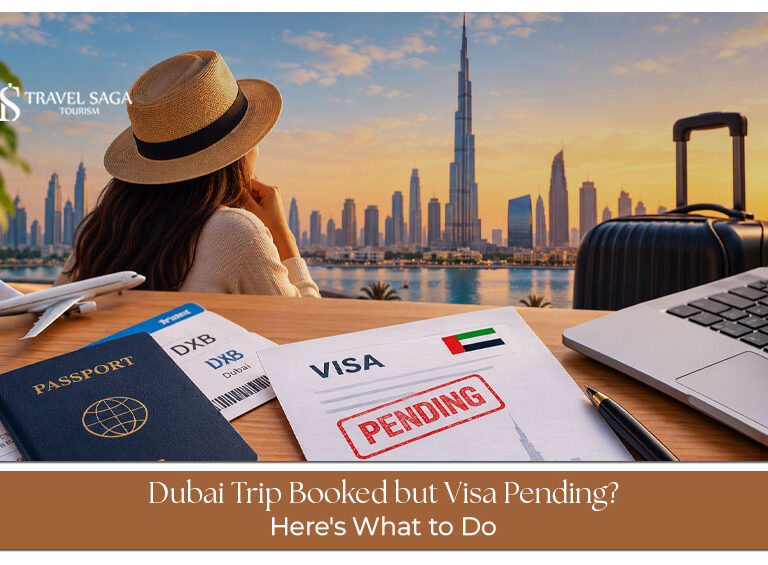 Traveller checking a pending visa application on a laptop beside a passport and confirmed Dubai flight booking.