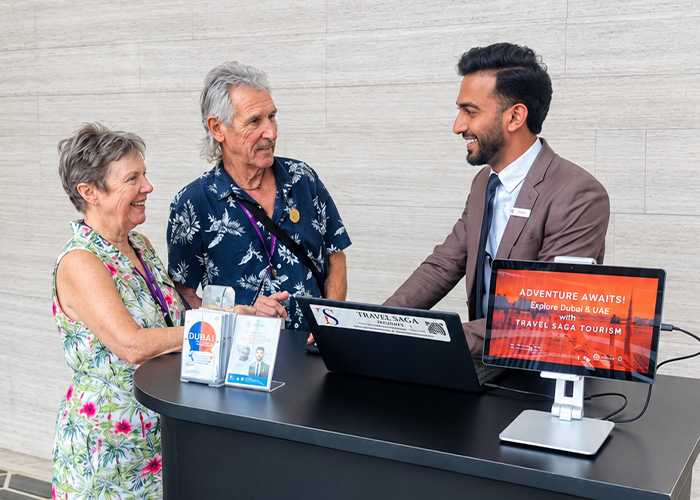 Travel Saga Tourism representative assisting customers at the Dubai tour desk